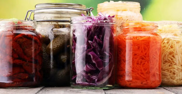Assortment of colorful jars filled with pickled garden vegetables