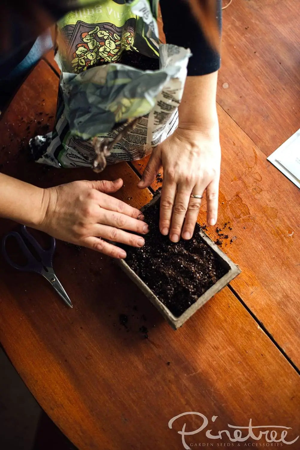 Filling a fiber pack tray with soil for seed starting