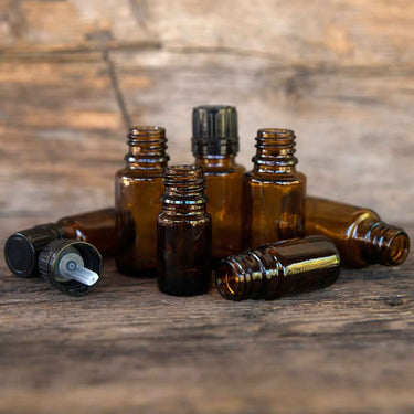 Amber glass essential oil bottles on a wooden surface.